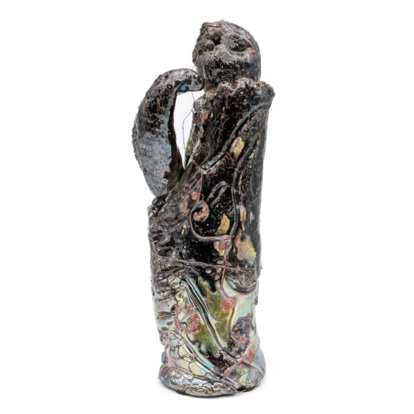 Tall abstract sculpture featuring a round head with a face. A cobra's head rises to face the figure.