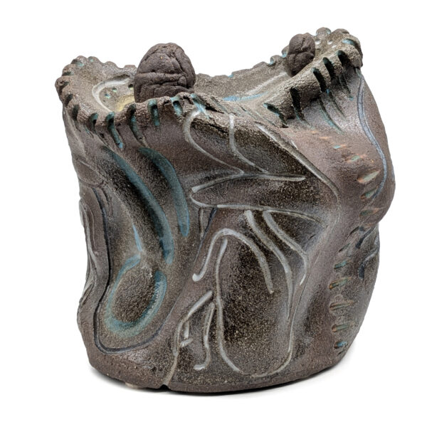 Abstract wavy gray sculpture. The piece has ridged edges along the top. The sides have white and blue lines