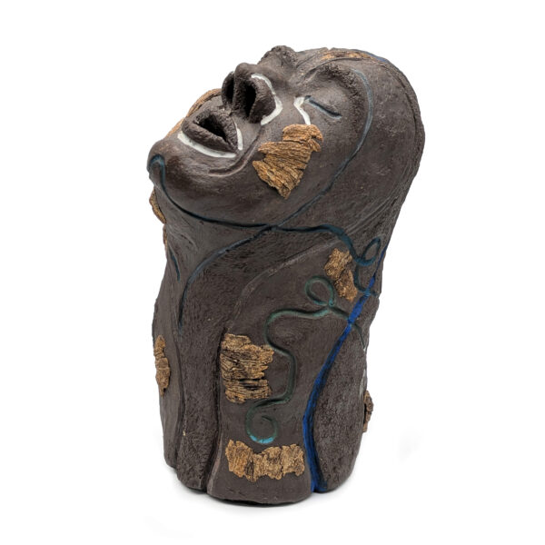 Dark gray sculpture features a face, tilted up, supported by a long and wide neck. The eyes are closed. There are abstract gold images painted on the sculpture.