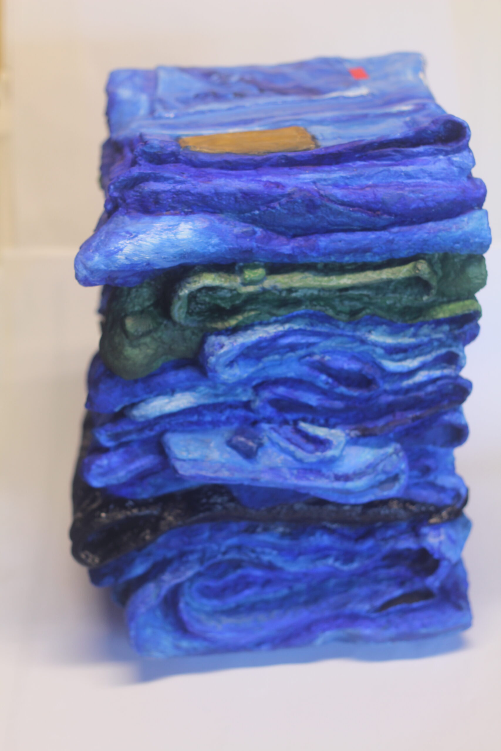 Photograph showing 3d art piece. The art is a stack of blue jeans.