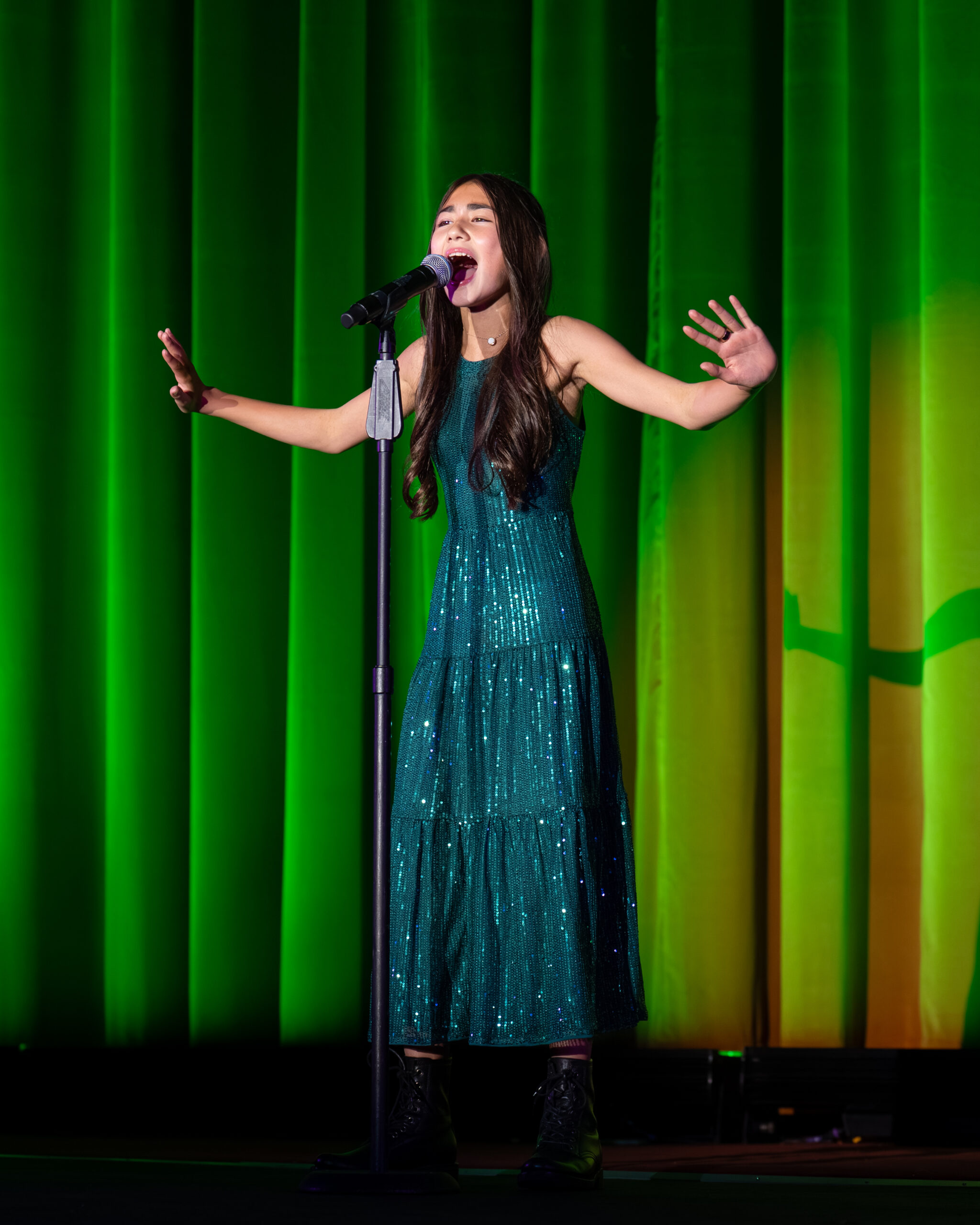 Photo shows a Lamorinda Idol performer singing on stage