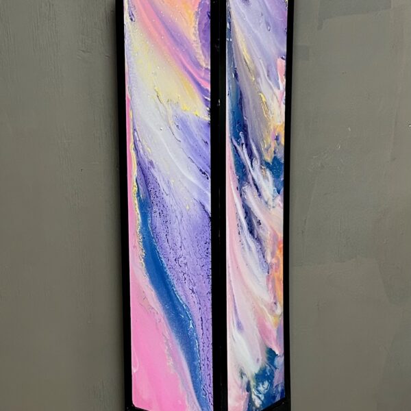 Photograph showing a tall black light box with multicolored panels in shades of blue, purple and yellow.