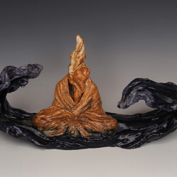 Image of sculpture of an abstract seated figure resembling an orange flame. Waves approach from both sides.