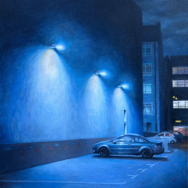 Image shows a car in a parking lot with blue streetlights illuminating the scene