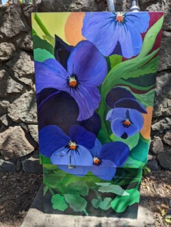 Utility box by Ruth McMillian, located in front of the stone wall in front of the community park